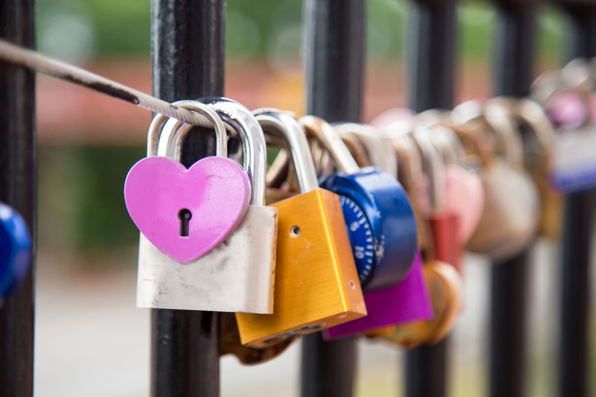 Close up of row of love locks hanging on a bridge