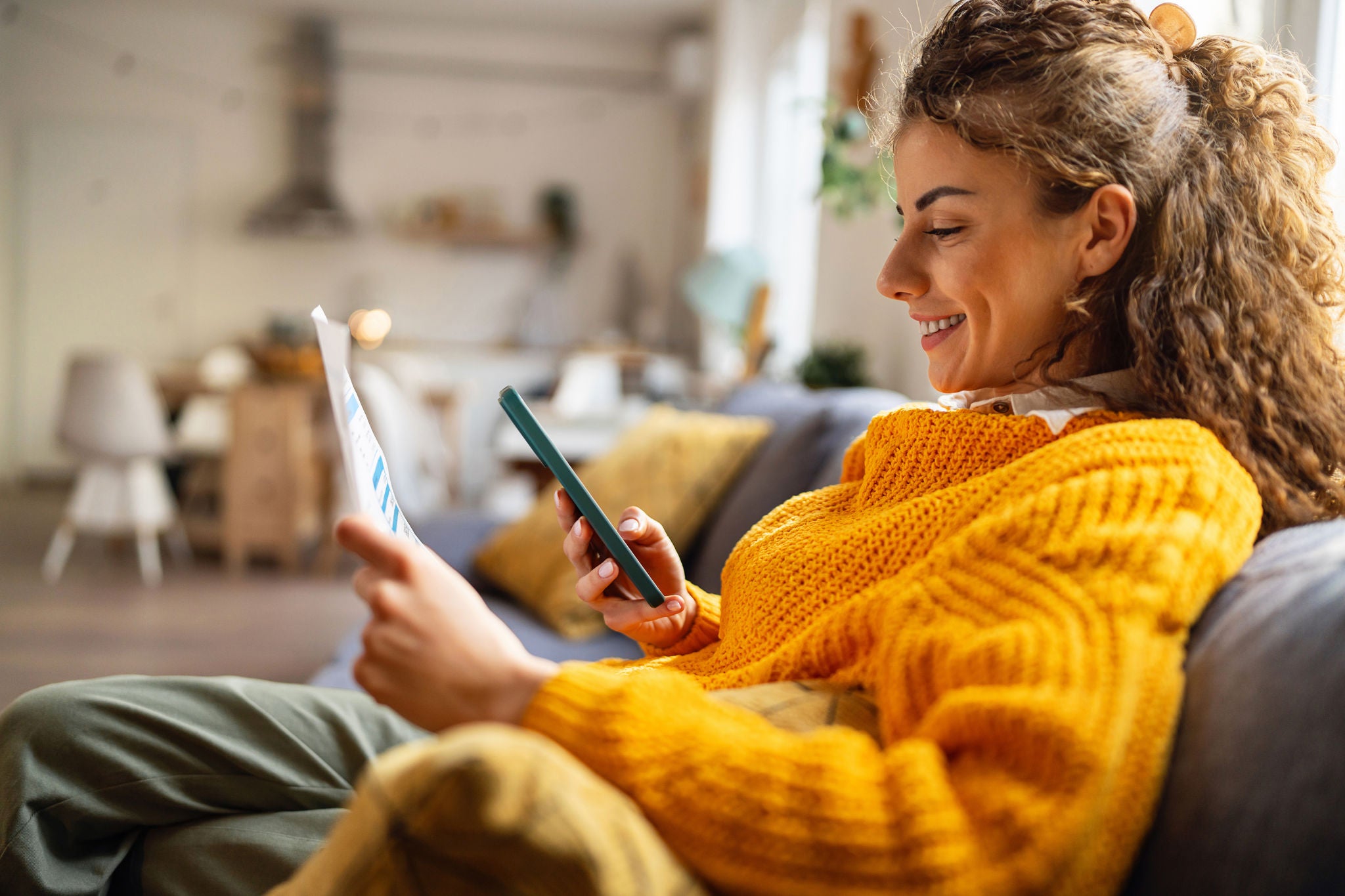 Side-view of an young Caucasian woman using smartphone for scanning the QR code and paying the bill